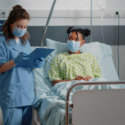 medical assistant doing consultation with ill patient wearing face masks hospital ward nurse discussing with young woman about healthcare treatment taking notes during pandemic