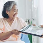 elderly patients injury woman patient s bed hospital holding us dollar bills feel happy from getting insurance money from insurance companies 1